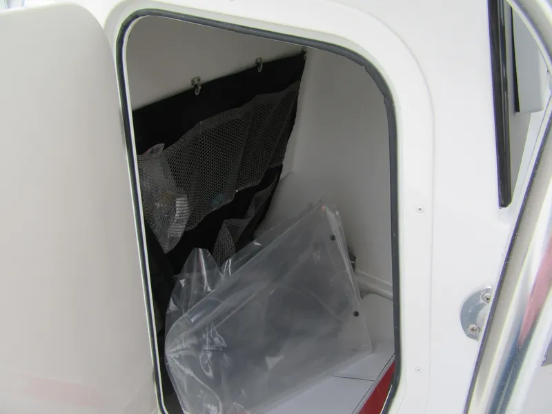 Slide: The Image of Storage compartment inside 2025 Parker 23SE Center Console boat, featuring mesh organizer. - 7