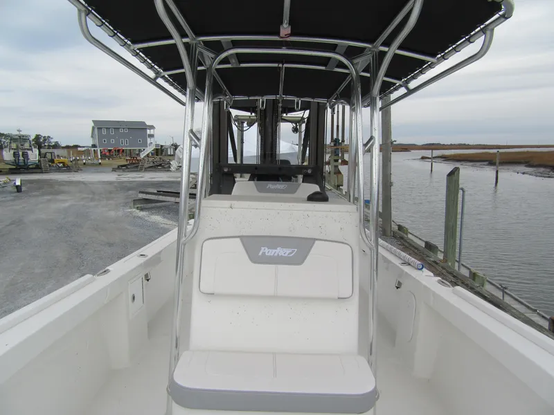 Slide: The Image of 2025 Parker 23SE Center Console boat docked near a waterfront, showcasing seating and console. - 9