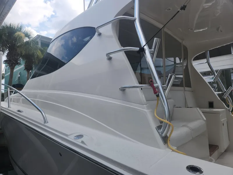 Slide: The Image of 2015 Jupiter 41 SB boat with sleek design and modern features, docked near palm trees. - 15