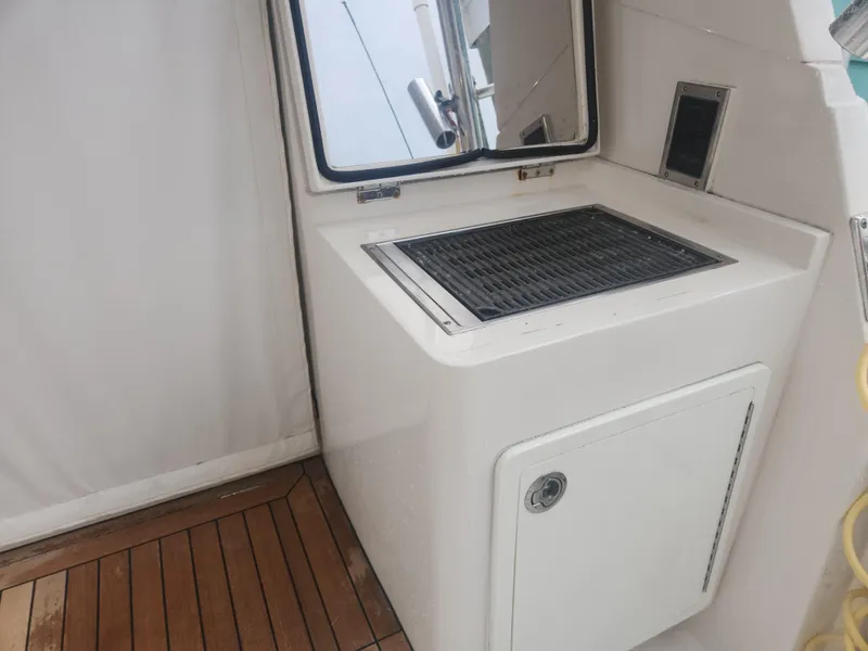 Slide: The Image of Outdoor grill station on 2015 Jupiter 41 SB boat with wooden deck flooring. - 16
