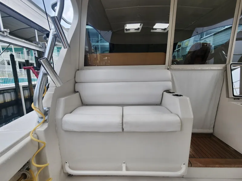 Slide: The Image of White seating area on a 2015 Jupiter 41 SB boat, docked at a marina. - 18
