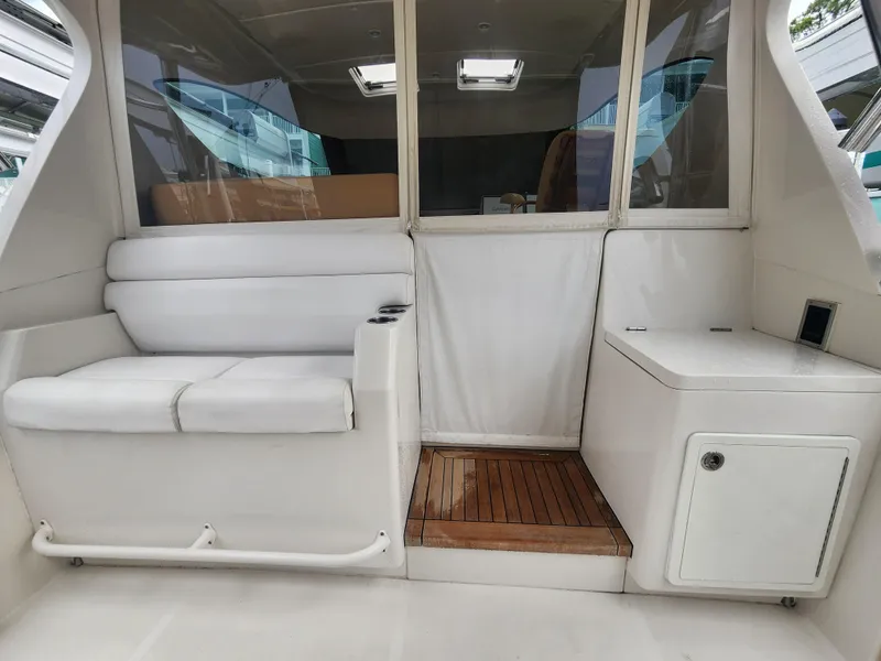 Slide: The Image of Interior of a 2015 Jupiter 41 SB boat with white seating and wooden flooring. - 20