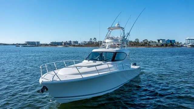 Slide: The Image of 2015 Jupiter 41 SB boat on calm water, clear sky, cityscape background. - 3
