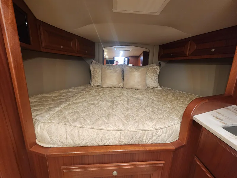 Slide: The Image of Cozy cabin interior of 2015 Jupiter 41 SB with plush bedding and wooden cabinetry. - 33