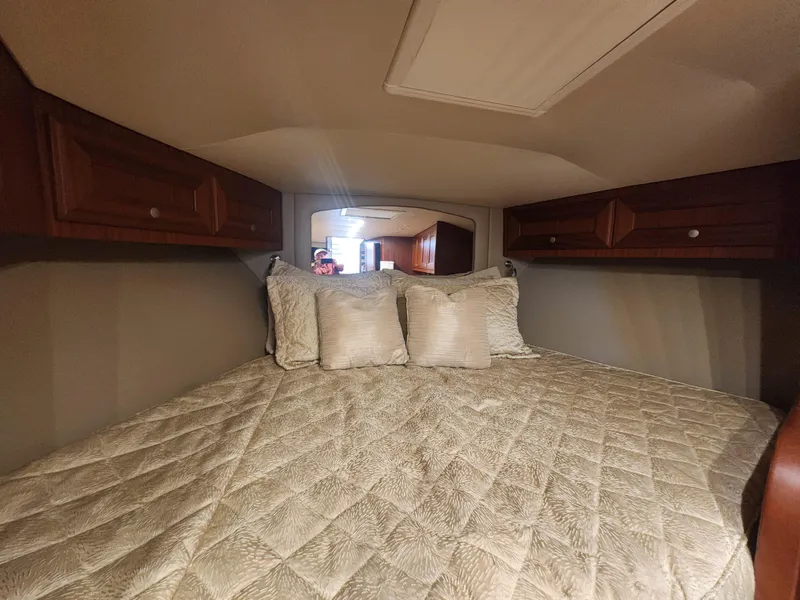 Slide: The Image of Cozy cabin bedroom in 2015 Jupiter 41 SB boat with quilted bedding and wooden cabinets. - 34