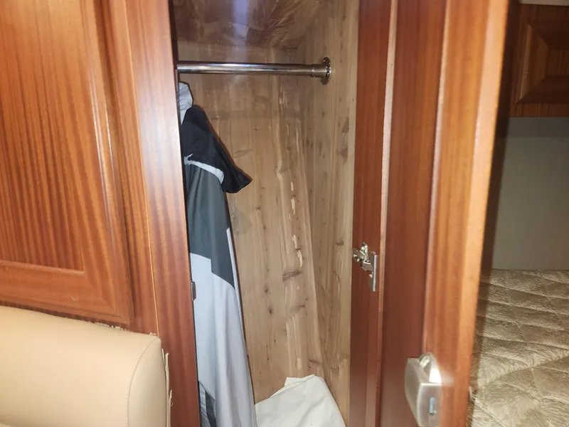 Slide: The Image of Wooden closet interior with hanging clothes in a 2015 Jupiter 41 SB boat. - 36