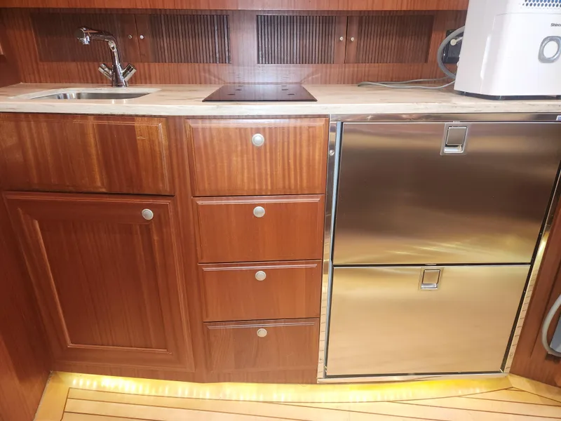 Slide: The Image of Wooden yacht kitchen with stainless steel appliances, featuring sink and storage. Jupiter 41 SB, 2015 model. - 37