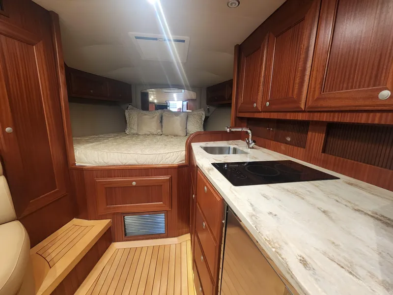 Slide: The Image of Luxurious interior of 2015 Jupiter 41 SB yacht with wood cabinetry and cozy sleeping area. - 38