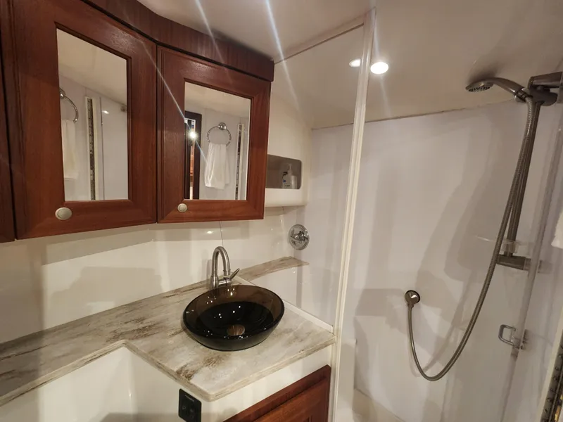 Slide: The Image of Luxurious bathroom in 2015 Jupiter 41 SB yacht with modern fixtures and wooden cabinetry. - 41