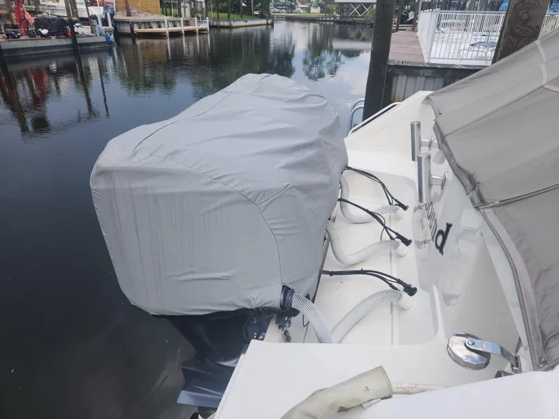 Slide: The Image of Covered outboard motor on a 2015 Jupiter 41 SB boat docked by a calm waterfront. - 9