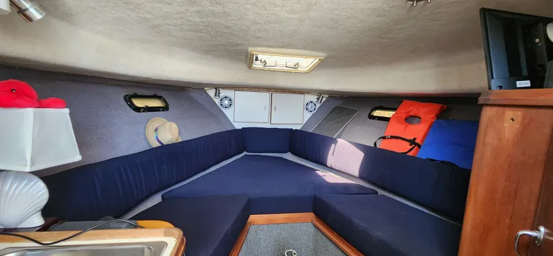 Slide: The Image of Interior of 1988 Tiara Yachts 2700 Open, featuring cozy seating and nautical decor. - 15