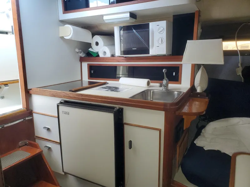 Slide: The Image of 1988 Tiara Yachts 2700 Open cabin kitchen with sink, microwave, and mini fridge. - 18
