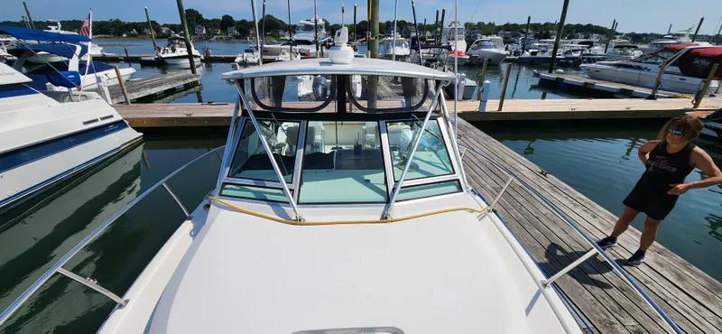 Slide: The Image of 1988 Tiara Yachts 2700 Open docked at marina, surrounded by other boats. - 2