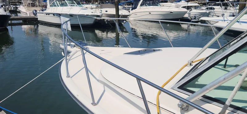 Slide: The Image of 1988 Tiara Yachts 2700 Open docked in a marina, surrounded by other boats. - 3