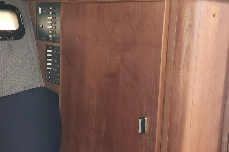 Slide: The Image of 1988 Tiara Yachts 2700 Open interior with wooden paneling and control switches. - 32