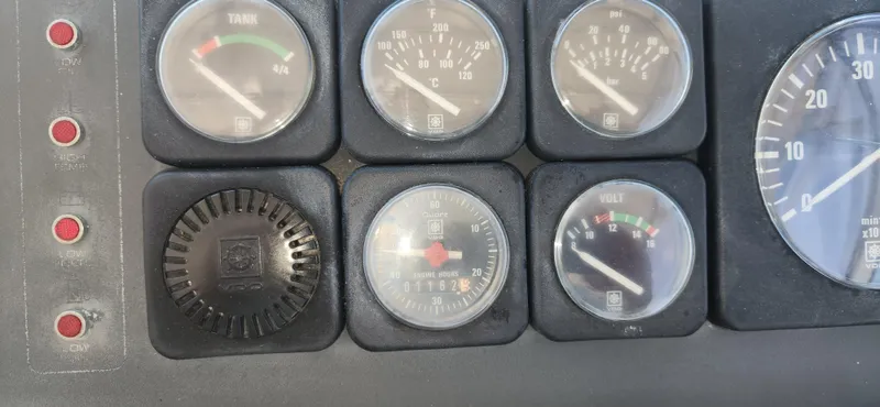 Slide: The Image of Dashboard gauges of a 1988 Tiara Yachts 2700 Open, displaying fuel, temperature, and voltage. - 37