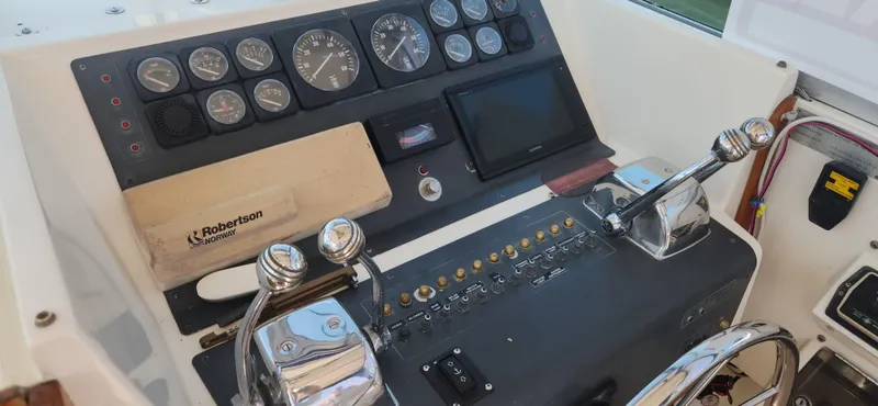 Slide: The Image of Control panel of a 1988 Tiara Yachts 2700 Open with gauges and levers. - 40