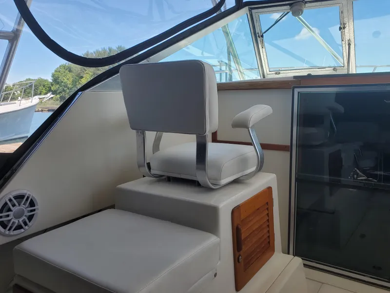 Slide: The Image of 1988 Tiara Yachts 2700 Open interior with white seating and window view. - 5