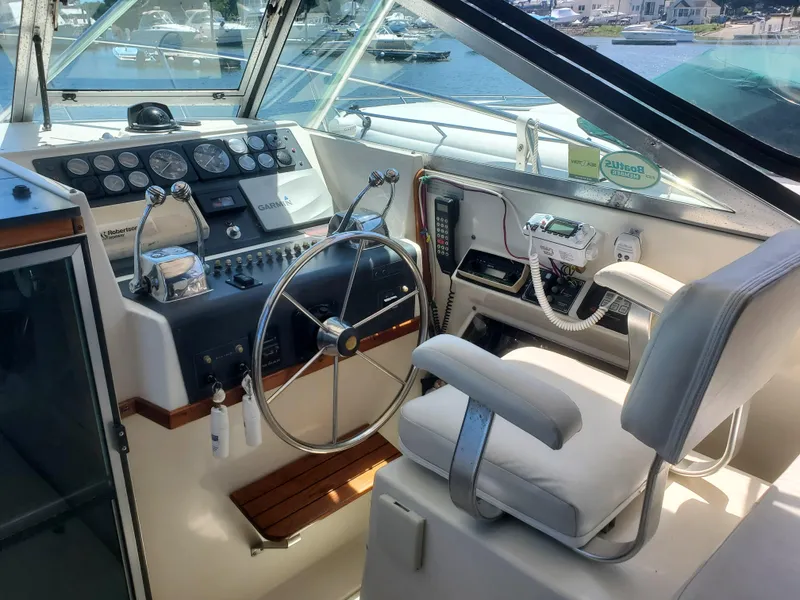 Slide: The Image of 1988 Tiara Yachts 2700 Open helm with steering wheel, controls, and navigation equipment. - 7