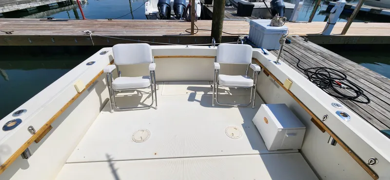 Slide: The Image of 1988 Tiara Yachts 2700 Open boat deck with chairs, docked at marina. - 9