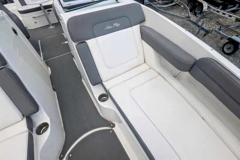 Slide: The Image of 2011 Sea Ray 260 Sundeck interior with white and gray seating, cup holders, and sleek design. - 11