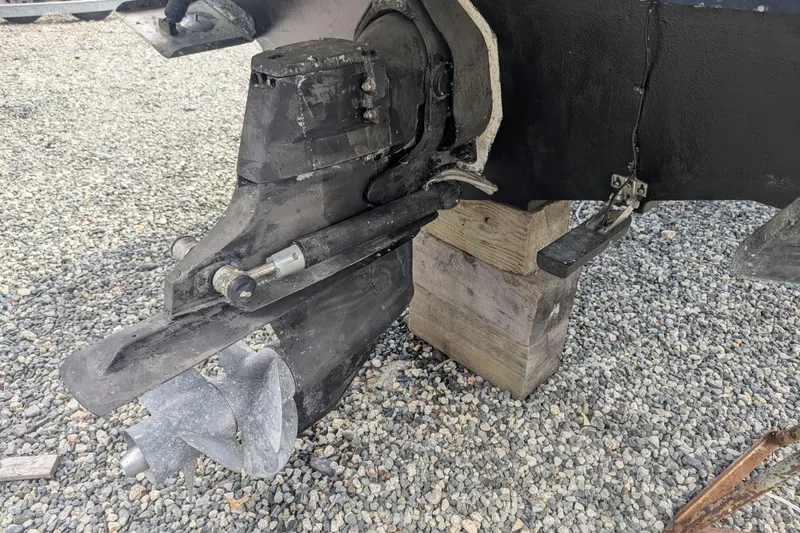 Slide: The Image of 2011 Sea Ray 260 Sundeck outboard motor on gravel, supported by wooden blocks. - 17