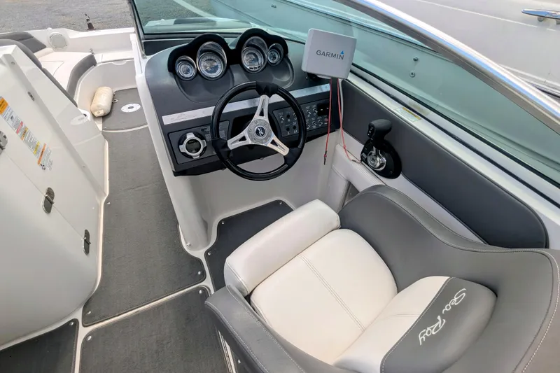 Slide: The Image of 2011 Sea Ray 260 Sundeck cockpit with steering wheel, Garmin GPS, and comfortable seating. - 2