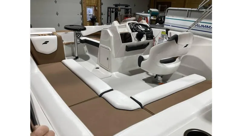 Slide: The Image of 2025 Starcraft SVX 191 OB boat interior with white and brown seating, steering console, and captain's chair. - 2