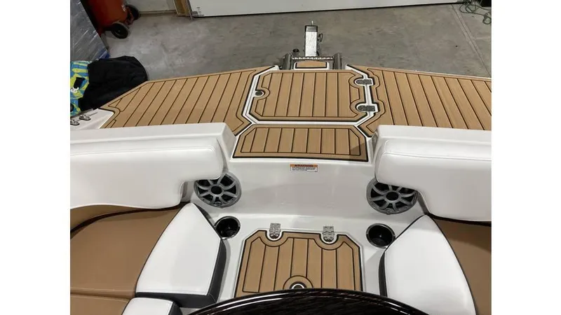 Slide: The Image of 2025 Starcraft SVX 191 OB boat interior with tan and white seating, wood-style flooring. - 4