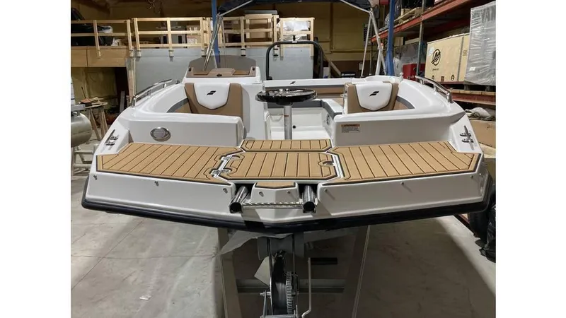 Slide: The Image of 2025 Starcraft SVX 191 OB boat in a workshop, featuring a sleek design and spacious deck. - 6