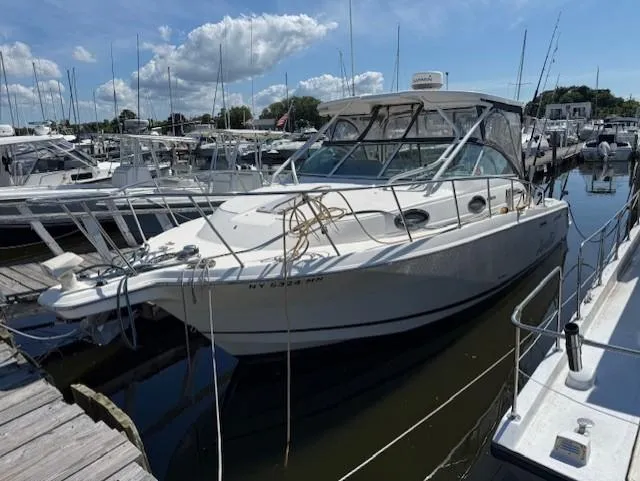 The Image of 2015 Wellcraft 290 Coastal boat docked at marina under blue sky. - 0