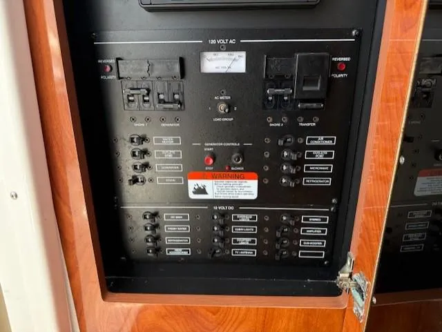 Slide: The Image of Electrical control panel on a 2015 Wellcraft 290 Coastal boat, featuring switches and warning labels. - 19