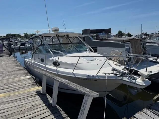 Slide: The Image of 2015 Wellcraft 290 Coastal boat docked at marina under clear blue sky. - 2