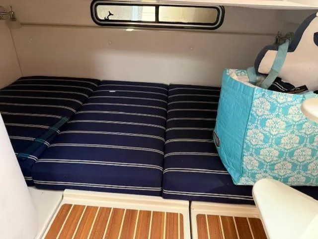 Slide: The Image of Interior cabin of 2015 Wellcraft 290 Coastal with striped cushions and storage bag. - 20