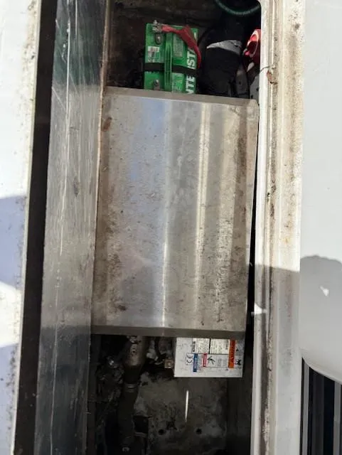 Slide: The Image of Engine compartment of a 2015 Wellcraft 290 Coastal boat, showing battery and metal components. - 23