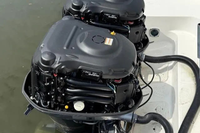Slide: The Image of Twin outboard engines on a 2015 Wellcraft 290 Coastal boat, docked in calm water. - 28