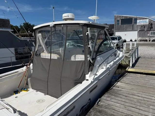 Slide: The Image of 2015 Wellcraft 290 Coastal boat docked, featuring enclosed cockpit and Garmin radar. - 3