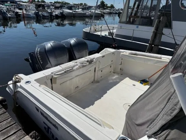 Slide: The Image of 2015 Wellcraft 290 Coastal boat docked, featuring spacious deck and dual Yamaha outboard engines. - 4