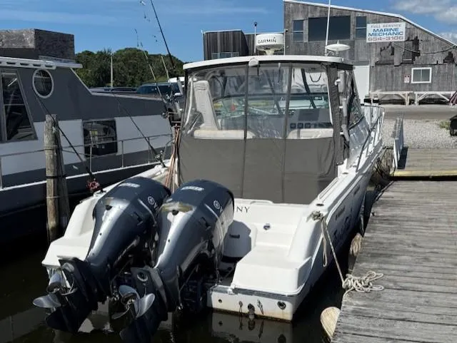 Slide: The Image of 2015 Wellcraft 290 Coastal boat docked with twin outboard engines. - 5