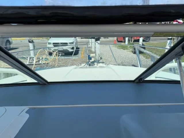 Slide: The Image of 2015 Wellcraft 290 Coastal boat interior view at marina, with parked cars visible outside. - 7