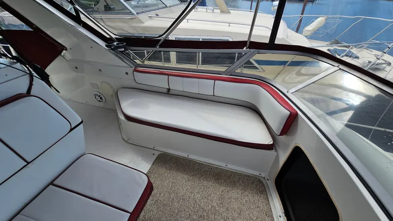 Slide: The Image of 1989 Carver 38 Santego yacht interior with white and red seating, docked at marina. - 11