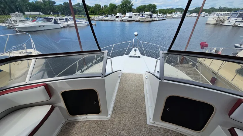 Slide: The Image of 1989 Carver 38 Santego yacht interior with marina view, featuring spacious seating and clear windows. - 13