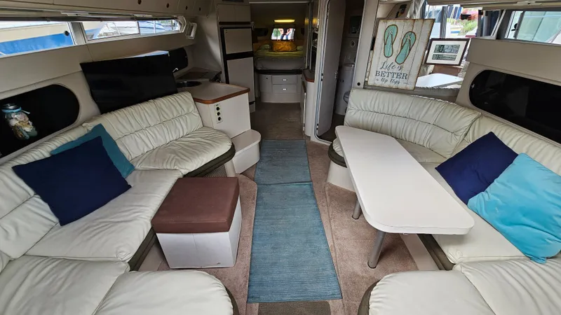 Slide: The Image of Interior of 1989 Carver 38 Santego yacht with white seating and blue accents. - 15