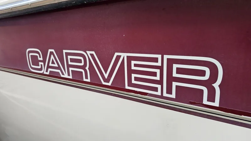 Slide: The Image of Close-up of 1989 Carver 38 Santego boat logo on maroon background. - 29