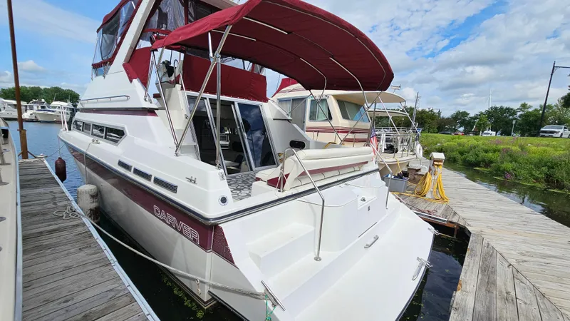 Slide: The Image of 1989 Carver 38 Santego yacht docked, featuring maroon canopy and sleek design. - 3
