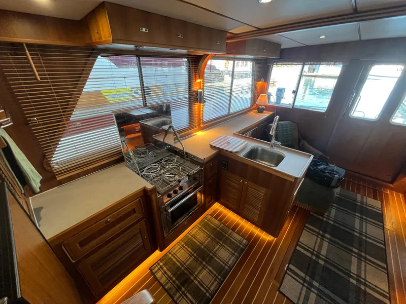 Slide: The Image of Luxurious interior of 2025 Helmsman Trawlers 43E Pilothouse with modern kitchen and wood finishes. - 11