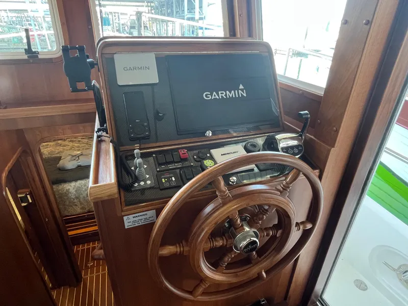 Slide: The Image of Pilothouse of 2025 Helmsman Trawlers 43E, featuring Garmin navigation and wooden steering wheel. - 15