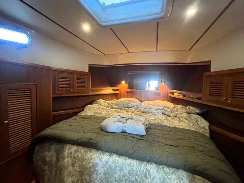 Slide: The Image of Luxurious cabin interior of 2025 Helmsman Trawlers 43E PILOTHOUSE with cozy bedding and wooden accents. - 16