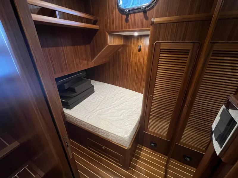 Slide: The Image of 2025 Helmsman Trawlers 43E PILOTHOUSE cabin with wooden interior and cozy bed. - 20
