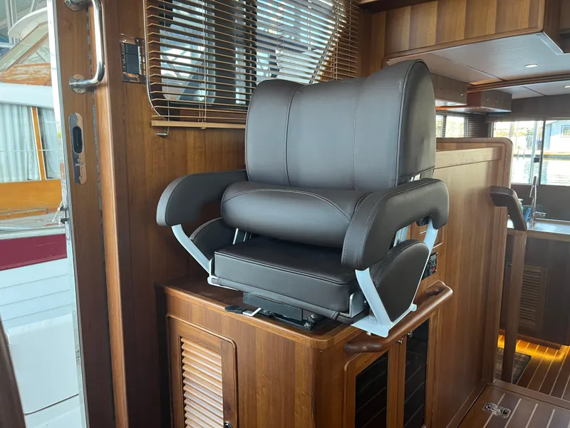 Slide: The Image of Luxurious leather pilothouse chair in 2025 Helmsman Trawlers 43E, featuring elegant wood interior. - 21